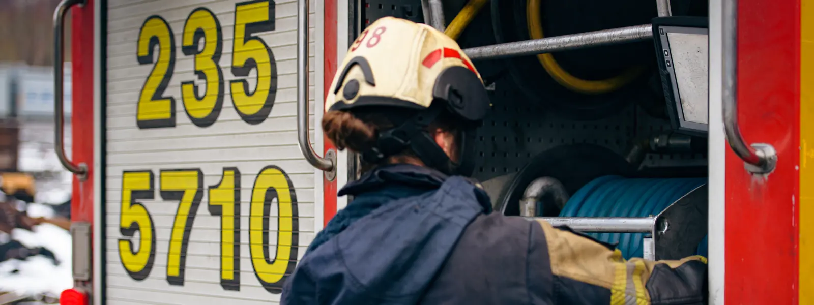 Brandman rullar in slang i brandbilen