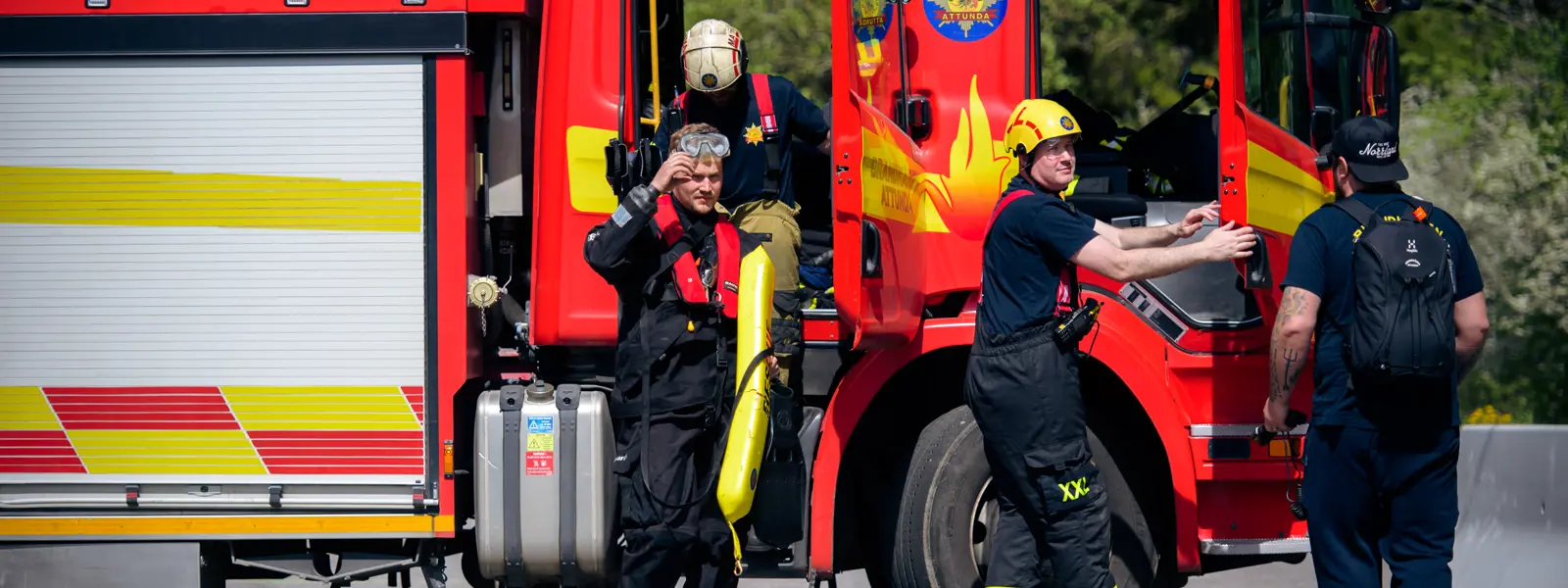 Brandmän som kliver ur brandbil på väg till räddningsdyk