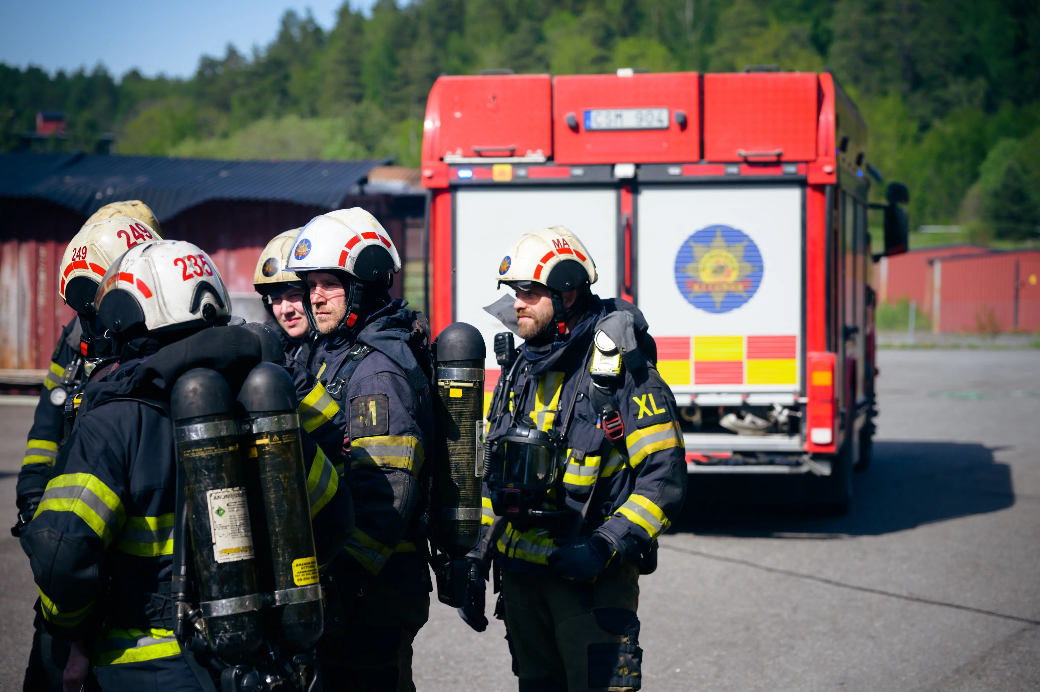 Flera brandmän utanför brandbil