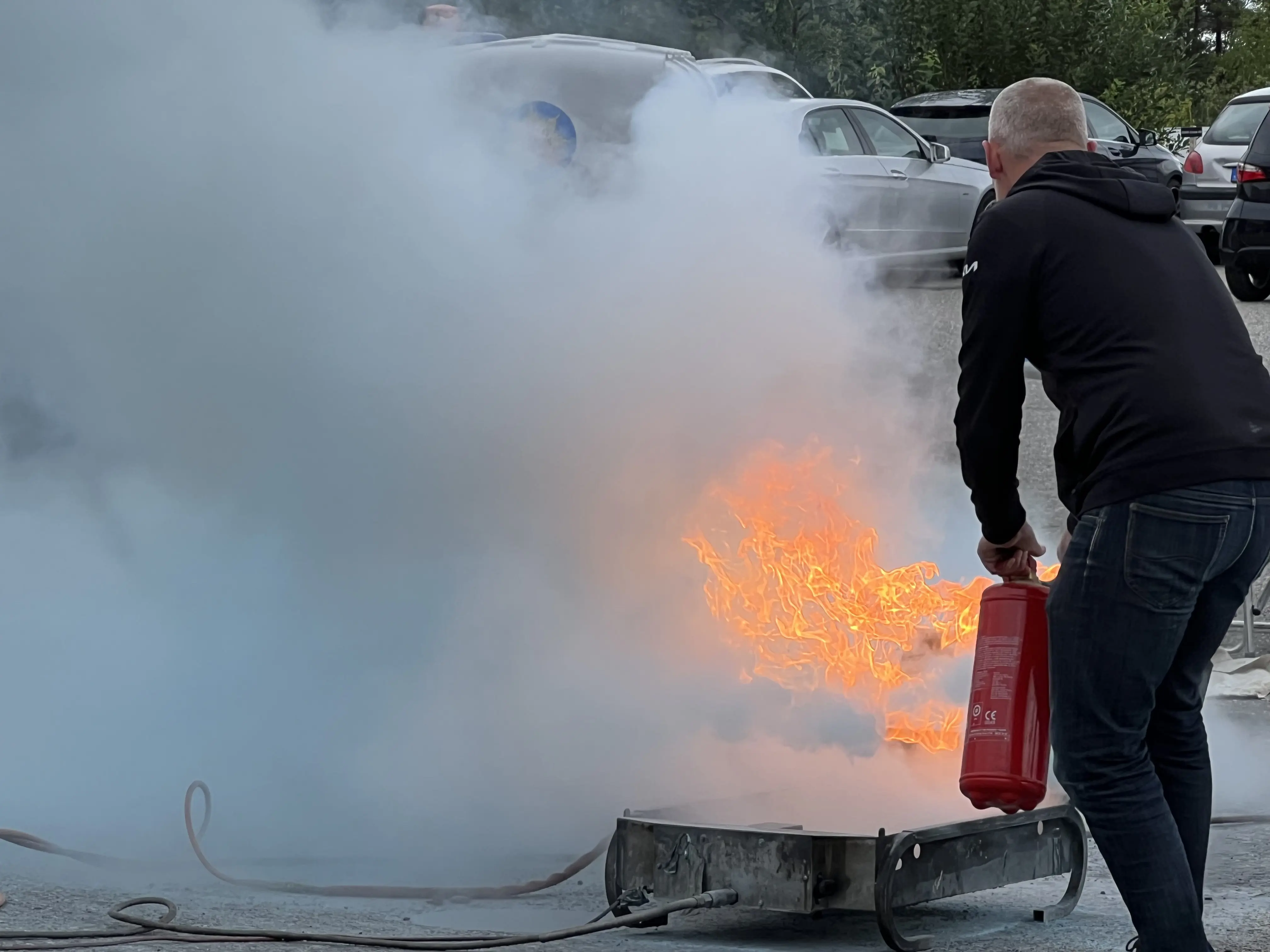 Manlig deltagare släcker brand med brandsläckare